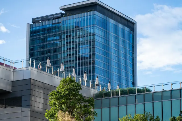 Glass office building under a blue sky